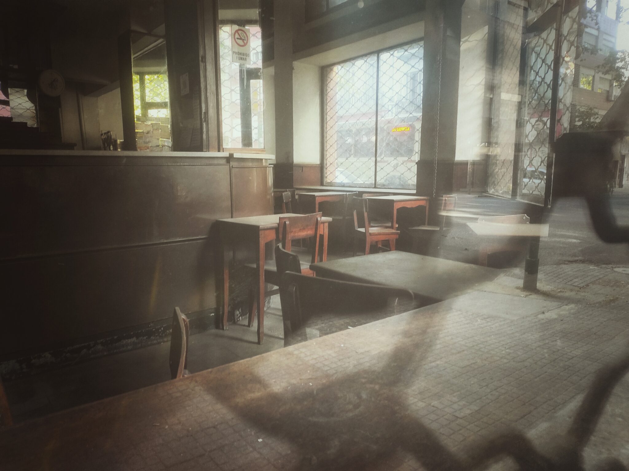 Un bar cerrado, con las mesas juntas y el mostrador vacío.